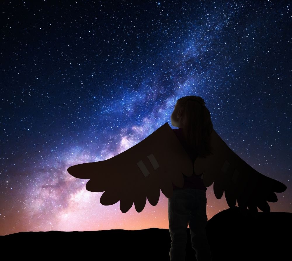 Girl with wings looking in wonder at the night sky